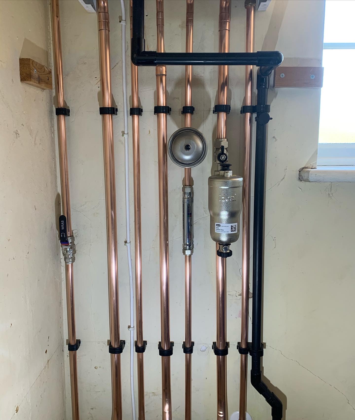 Neat vertical copper pipework with a magnetic filter and an expansion vessel