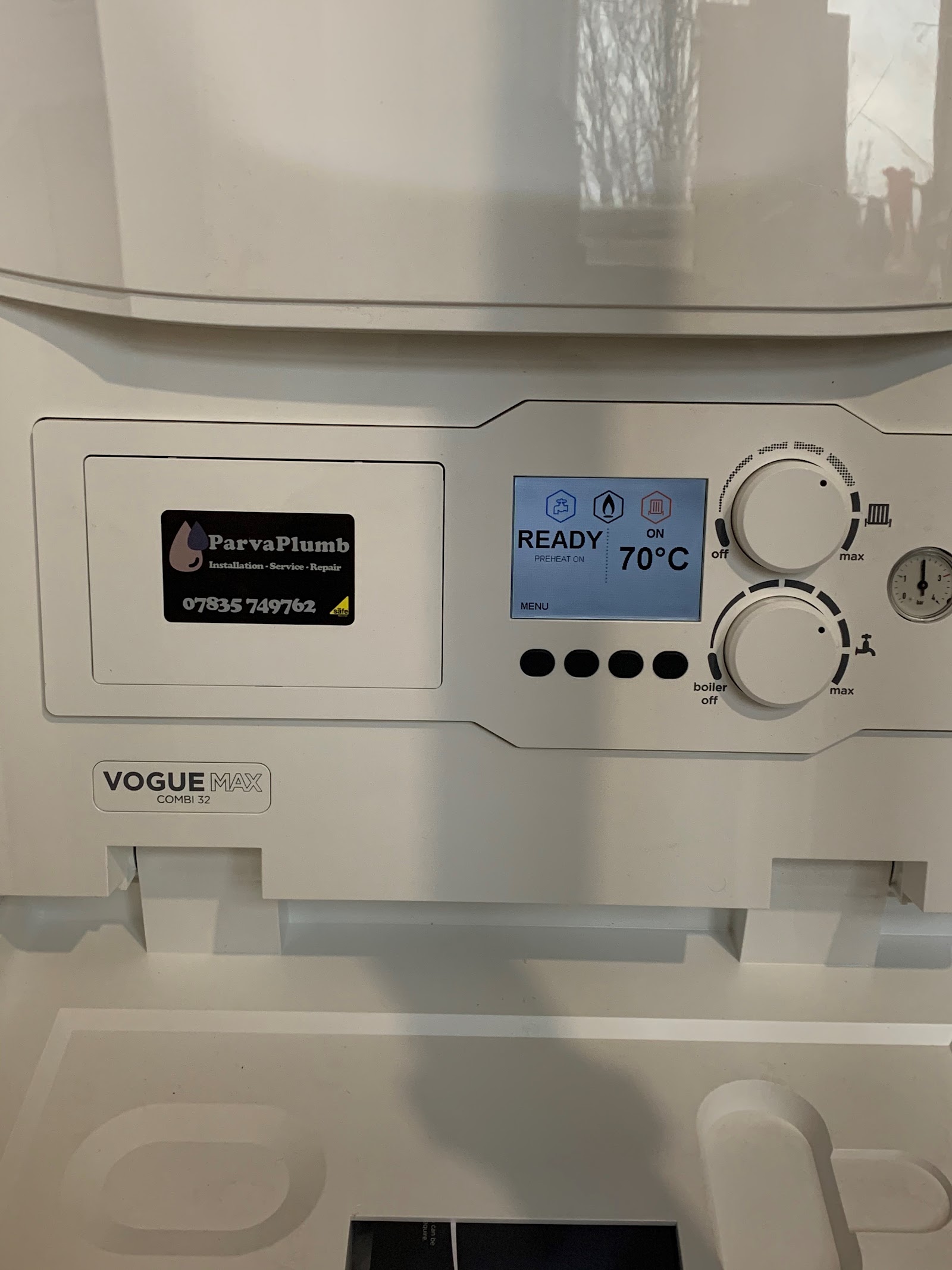 A boiler control panel reading READY 70°C with the ParvaPlumb service sticker beside it
