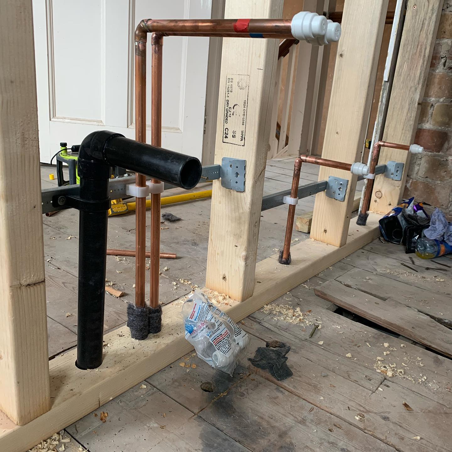 First-fix copper and waste pipework in a timber stud wall during a renovation