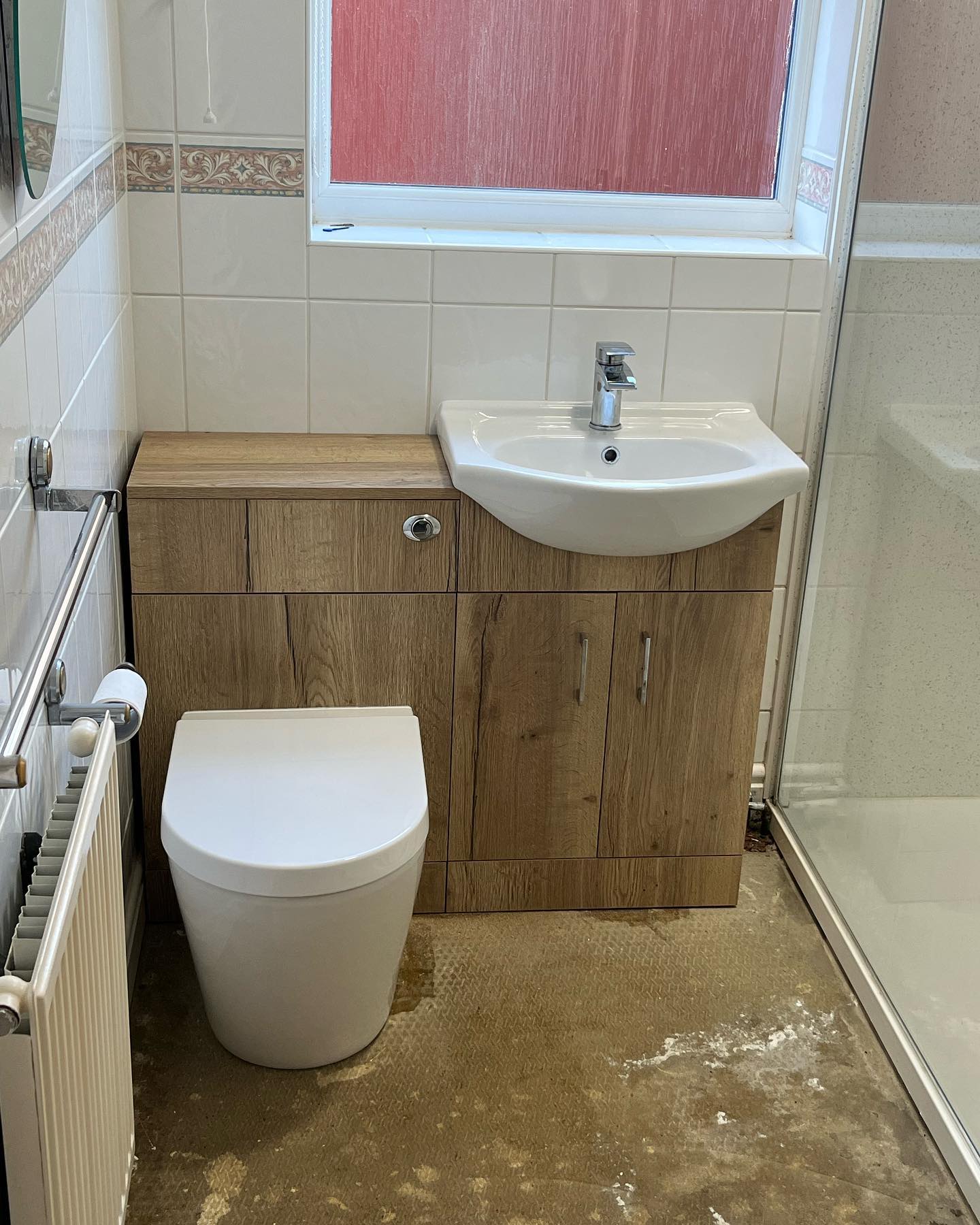 A bathroom with a new back-to-wall toilet, vanity basin unit and radiator